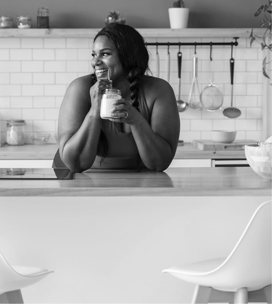 Woman sipping drink in kitchen